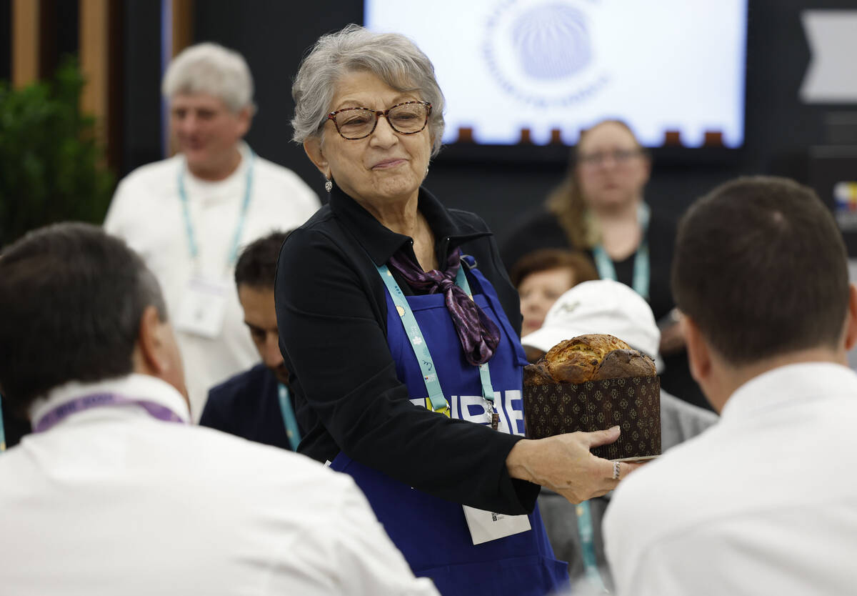 Volunteer Caryl Hepker provides samples of panettone to a pair of judges during the Panettone W ...