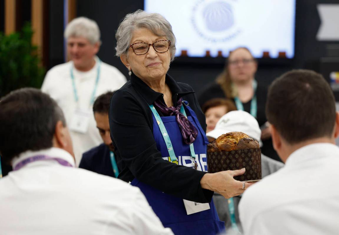 Volunteer Caryl Hepker provides samples of panettone to a pair of judges during the Panettone W ...