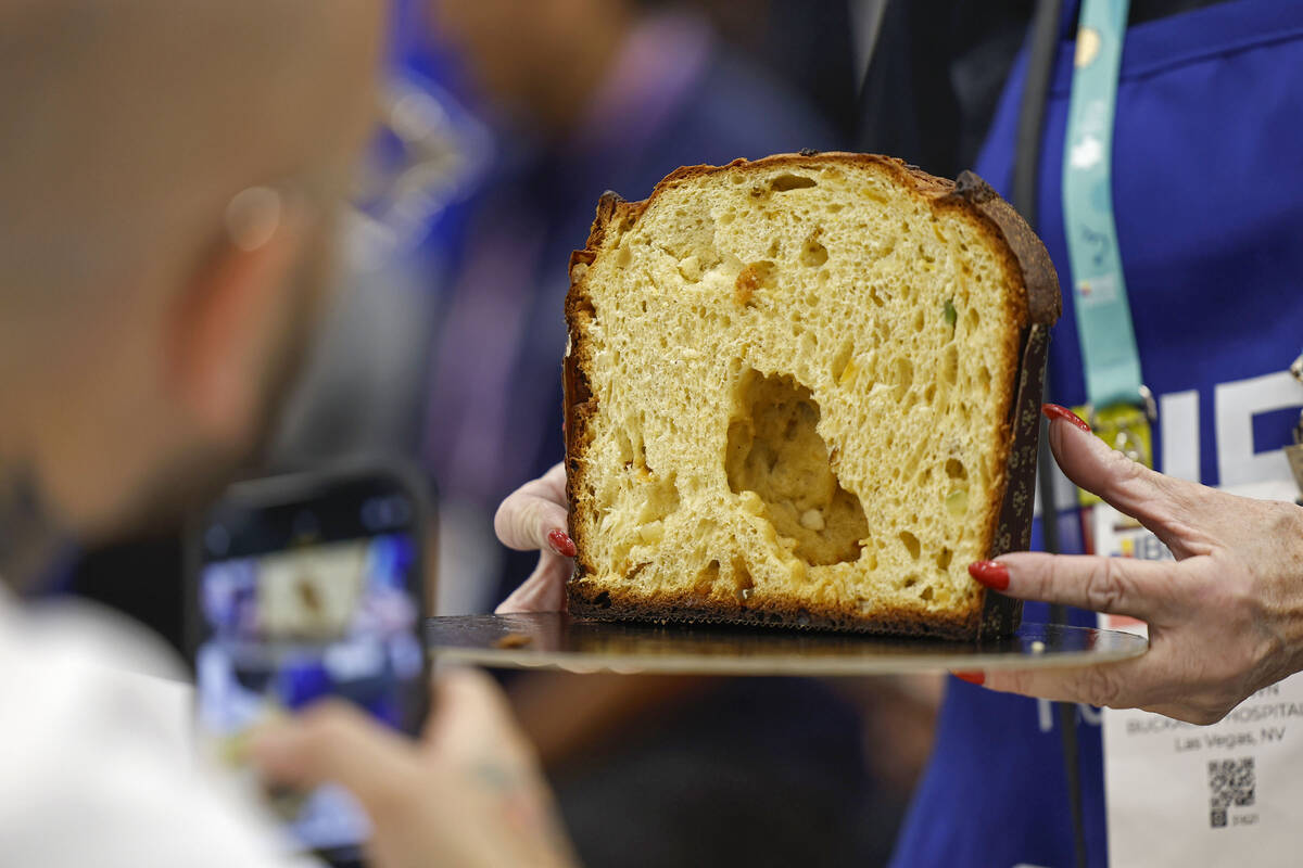 Judge and pastry chef Marco Lusso photographs a sample of panettone during the Panettone World ...