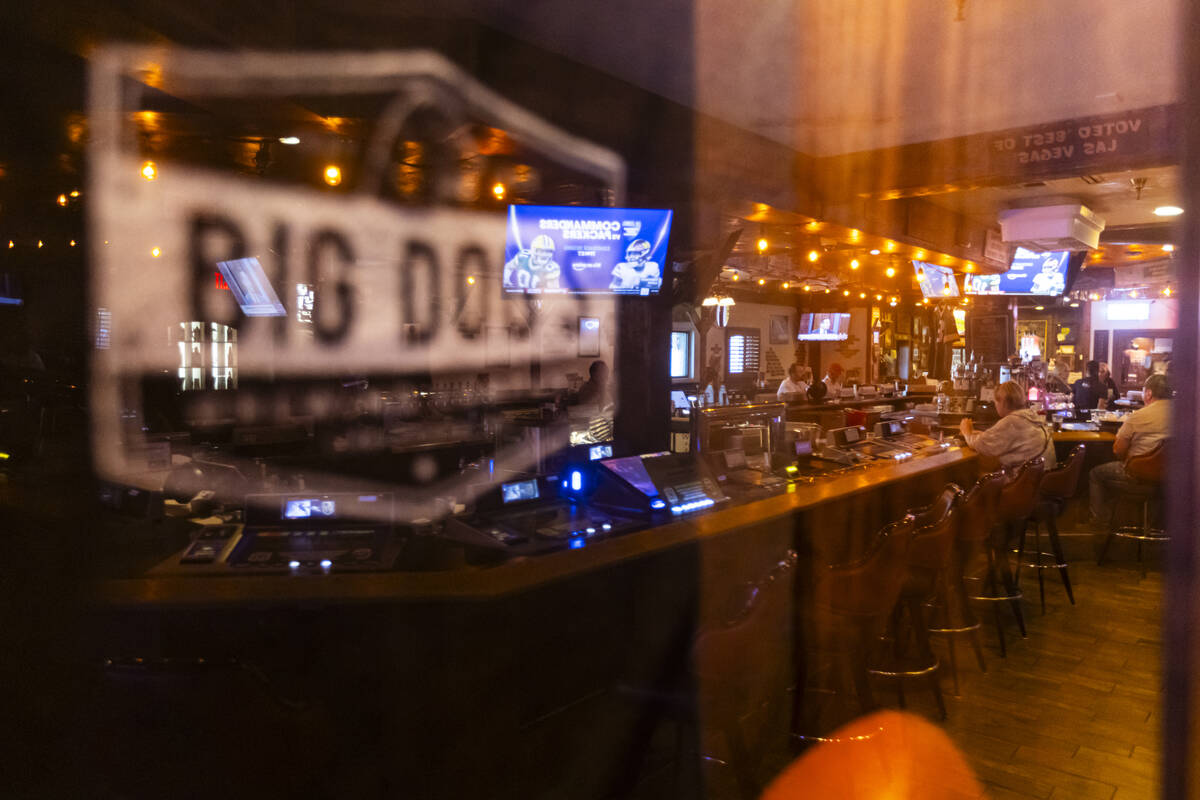 People are reflected in a display case at Big Dog’s Draft House, at 4543 N. Rancho Drive, on ...