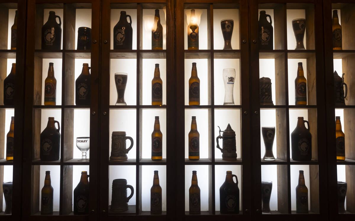 A variety of beer bottles, growlers, steins and mugs are seen by the entrance to Big Dog’s Dr ...