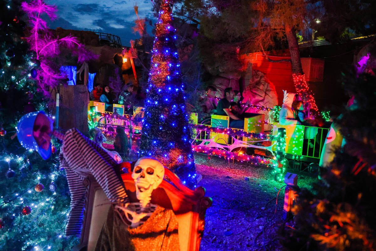 Passengers ride a mini train past Halloween decor during HallOVeen at the Magical Forest at Opp ...
