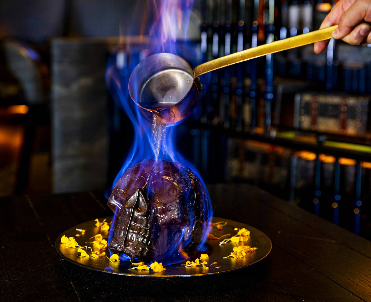 Hot chocolate mocha sauce is poured atop a Diablo Skull en Fuego dessert to reveal flan inside ...