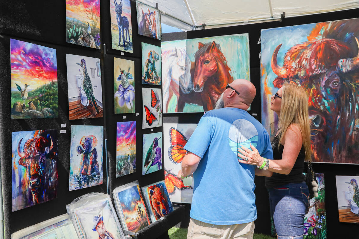 Monee Hays and Troy Harvey check out oil paintings made by Chuck Watkins at the annual Art In T ...