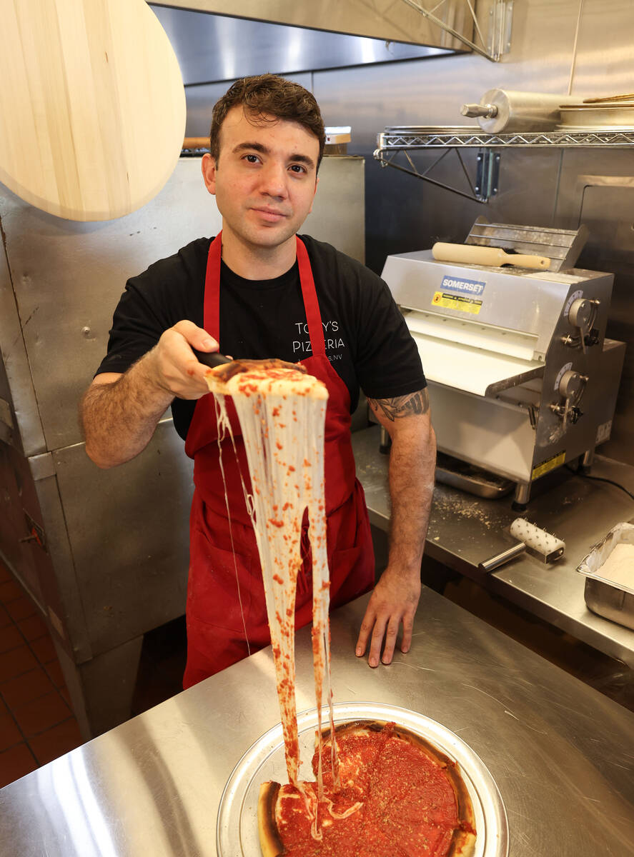 Tony’s Pizzeria co-owner Tony Cimino stretches the cheese of a 12” Chicago deep dish cheese ...
