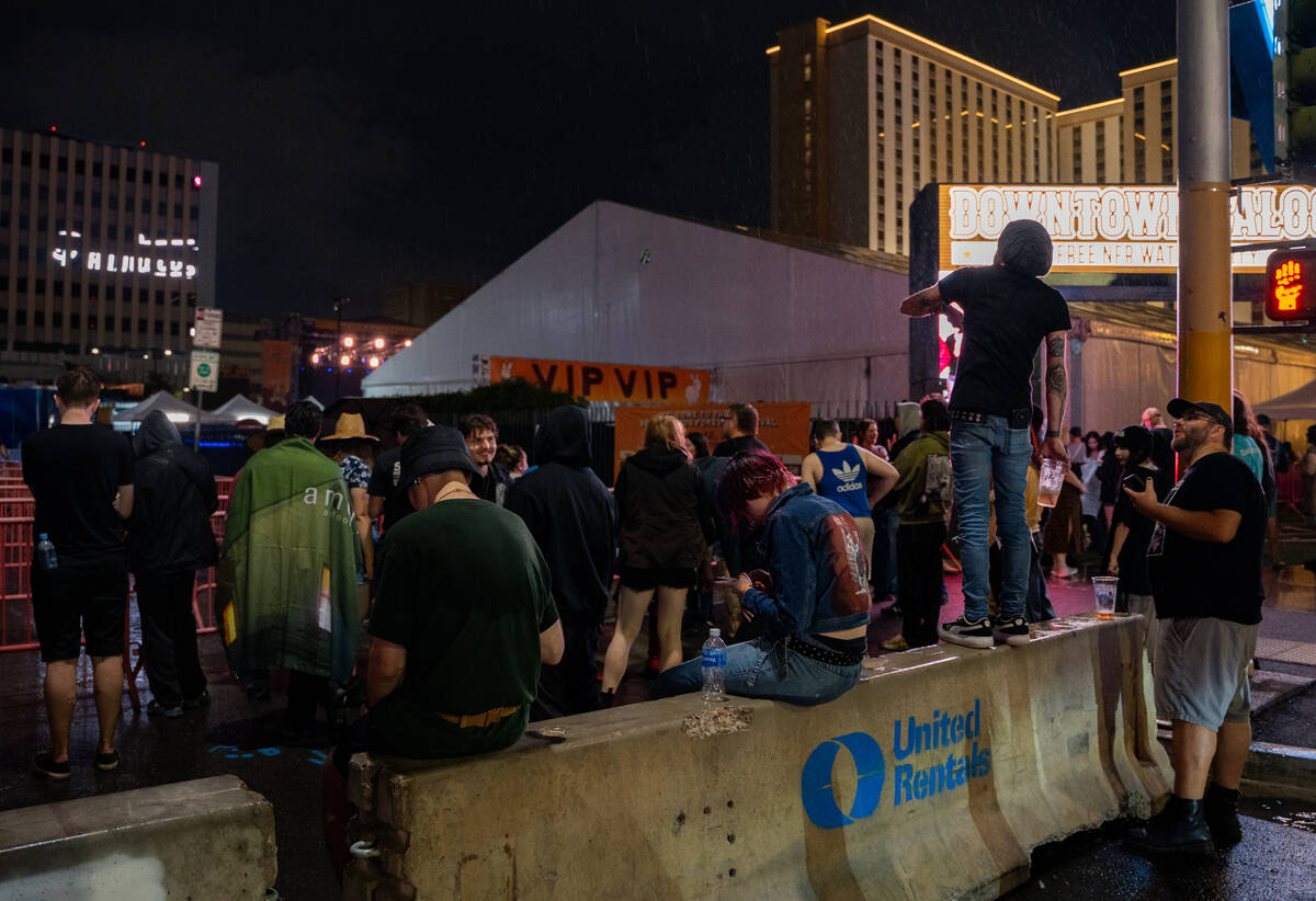 Concertgoers wait to hear updates about the Best Friends Forever Fest during a 90-minute rain d ...