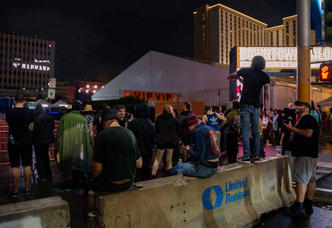 Concertgoers wait to hear updates about the Best Friends Forever Fest during a 90-minute rain d ...