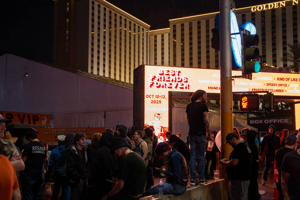 Concertgoers wait to hear updates about the Best Friends Forever Fest during a 90-minute rain d ...
