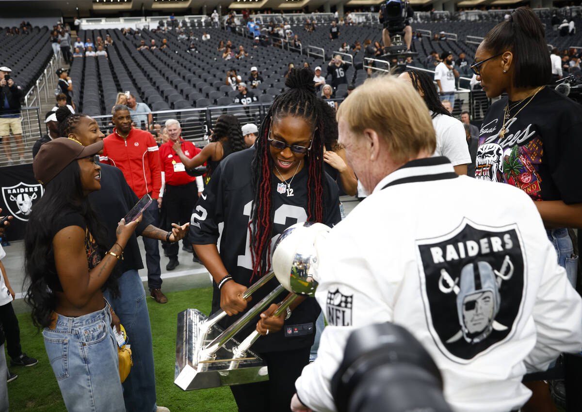 Aces’ Chelsea Gray shows off the team’s WNBA championship trophy to Raiders and A ...
