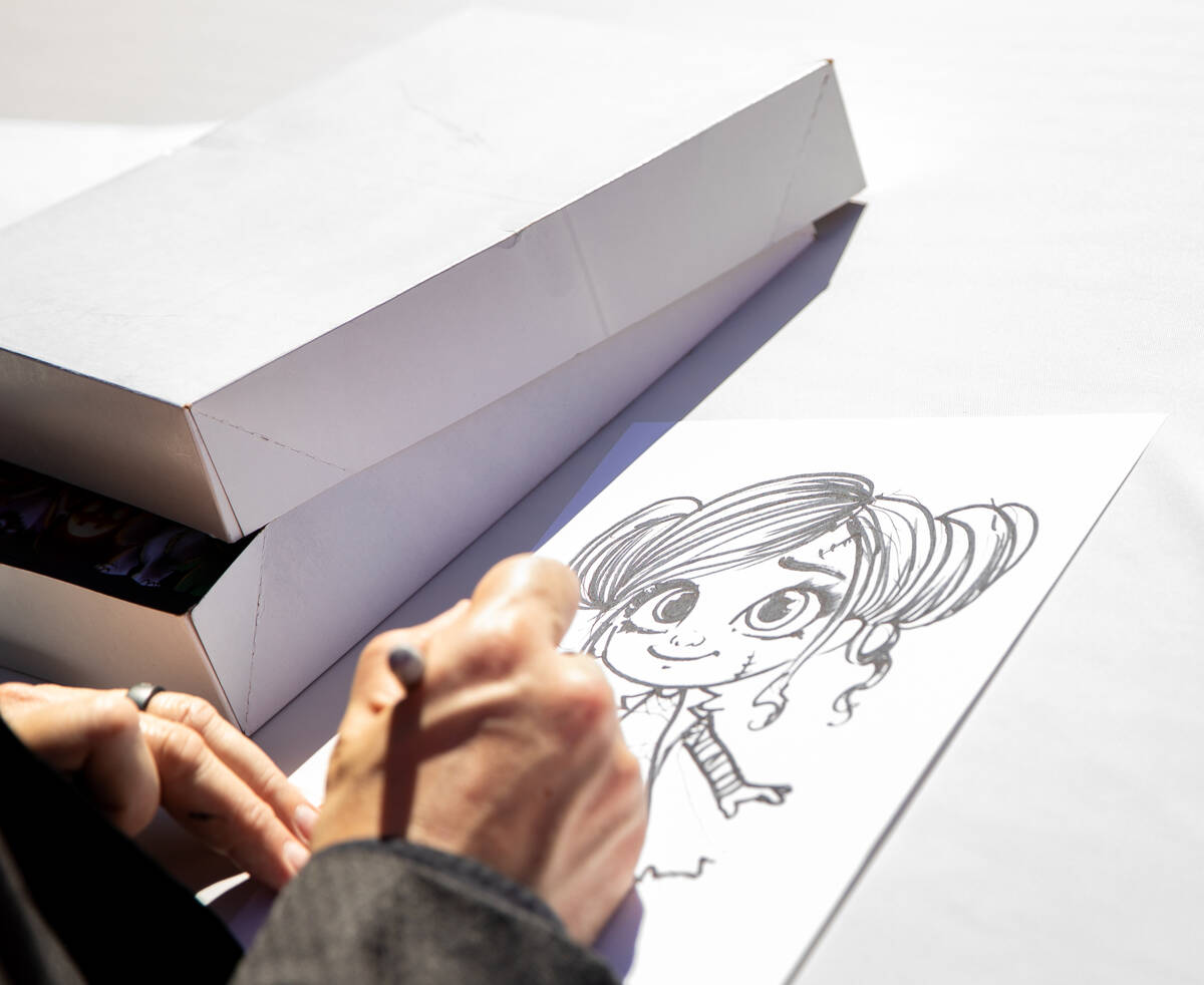 Artist James C. Mulligan draws a baby monster from “The Punkins” during an event ...