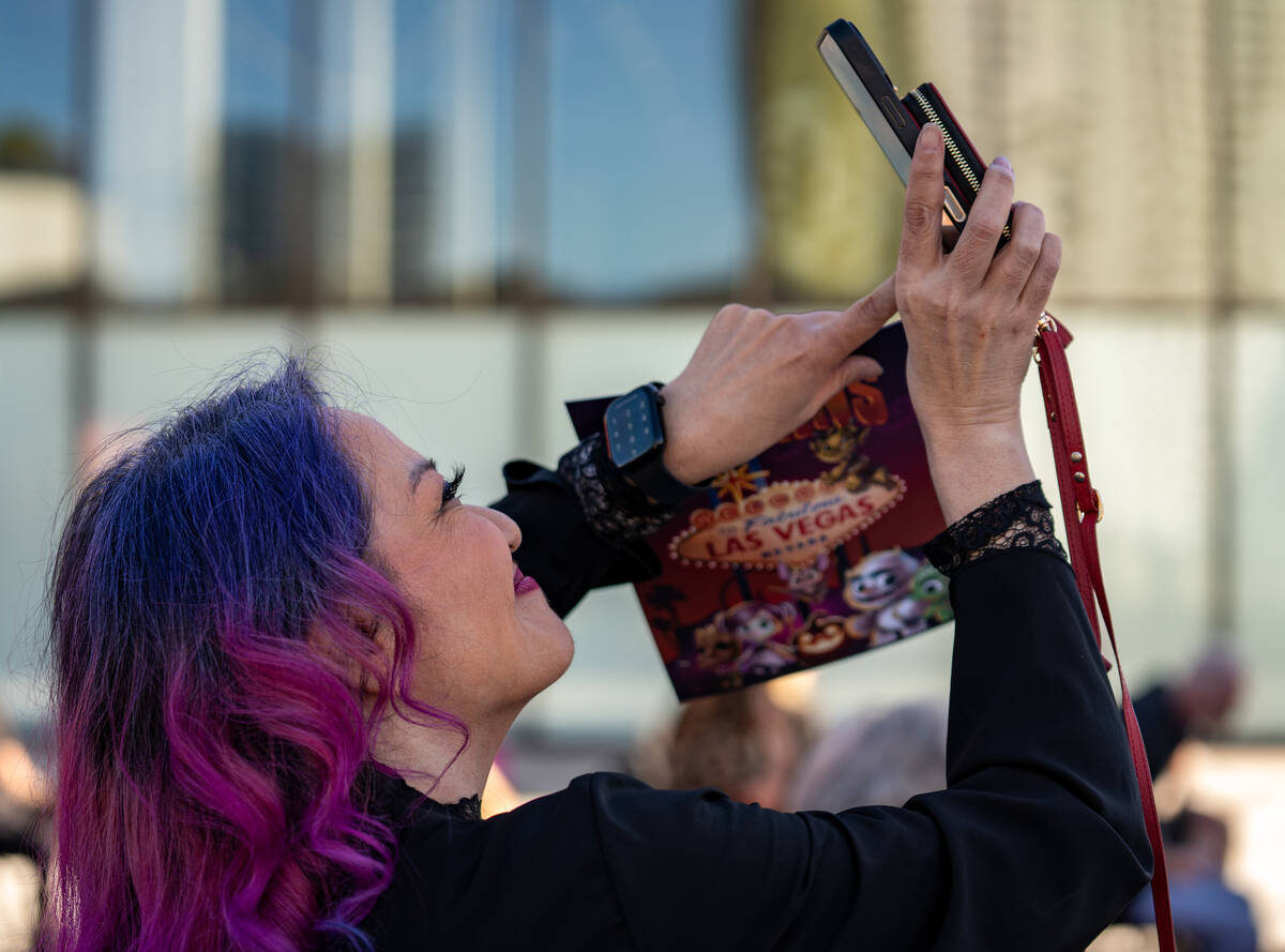 Tommy Brunswick photographs a billboard during an event announcing HallowScreamCon and HallowS ...