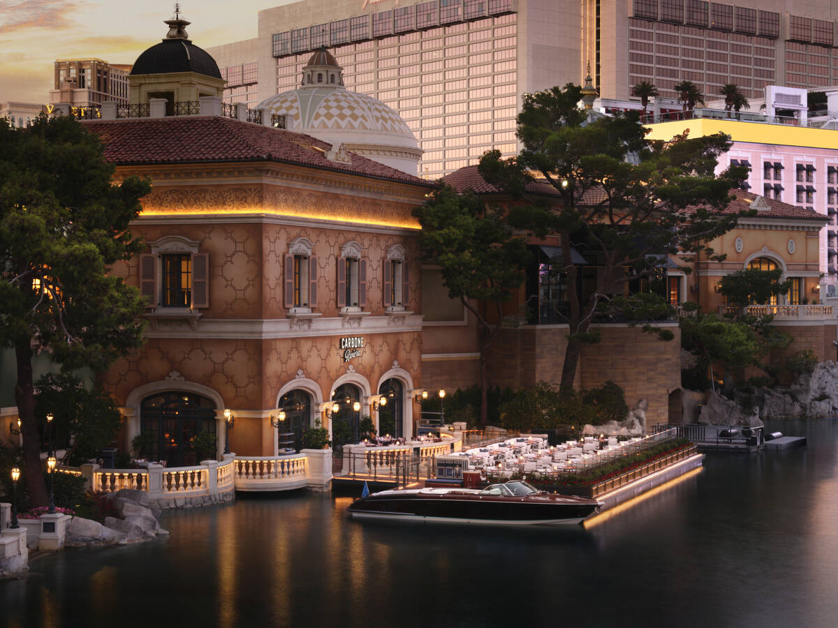 Deck seating lies in the foreground of this exterior image of Carbone Riviera on the shores of ...