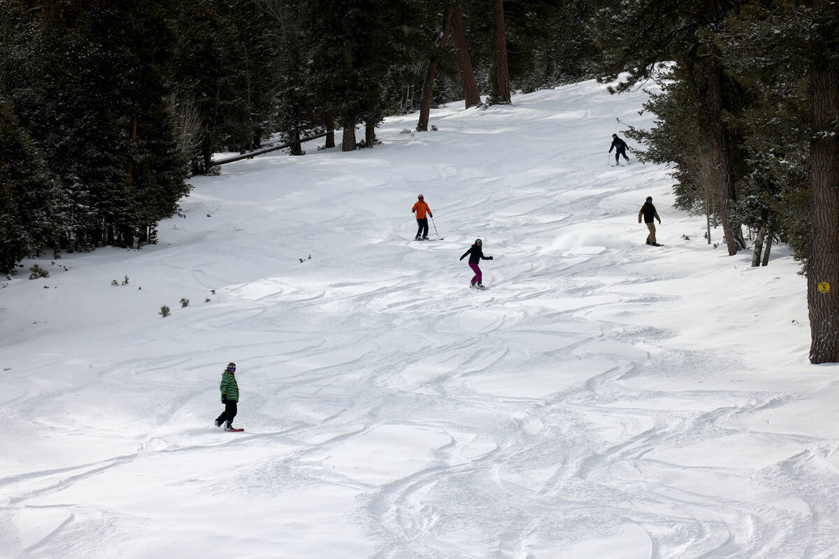 Skiers and snowboarders make turns on fresh snow just after opening at Lee Canyon on Mount Char ...