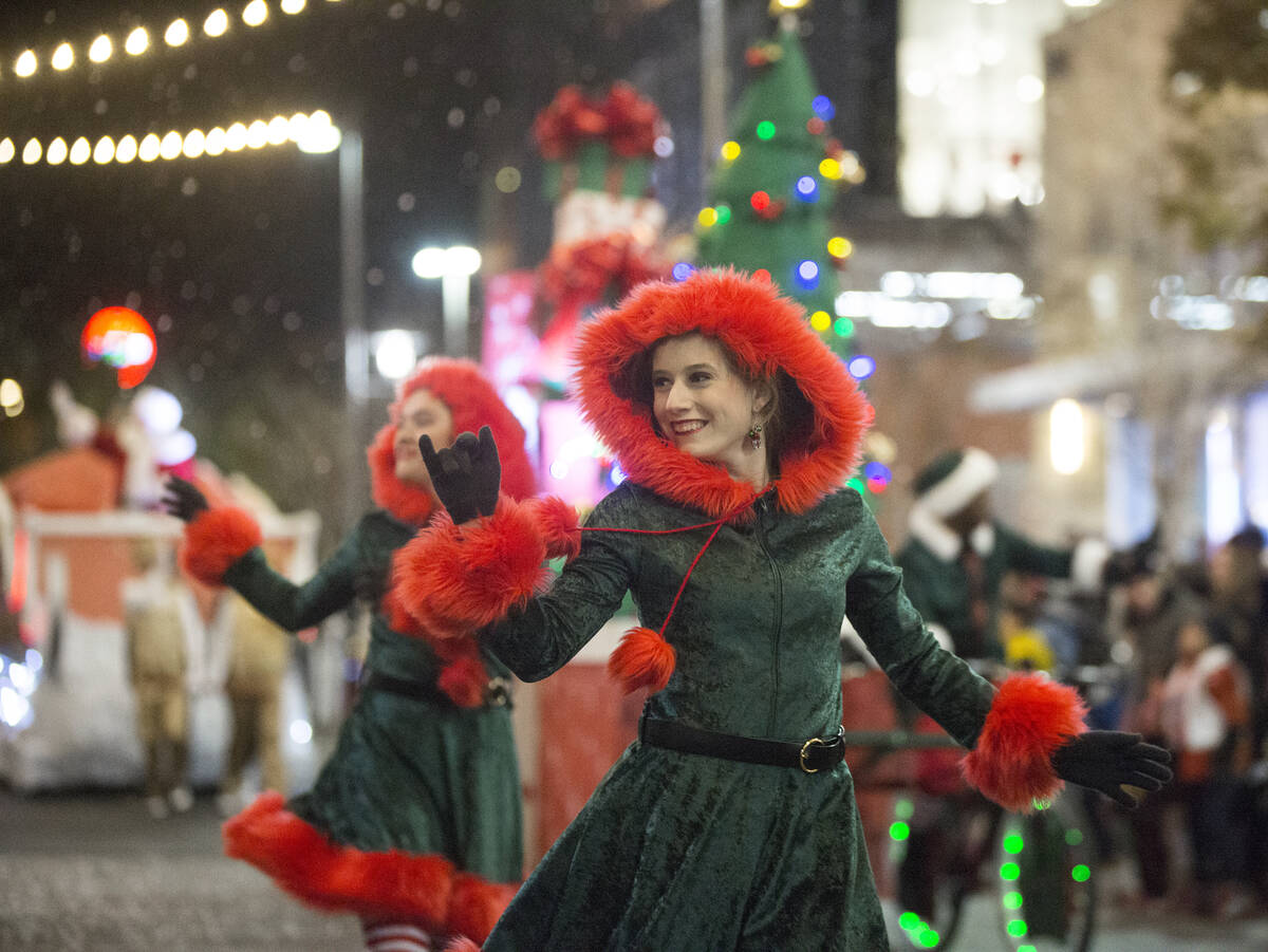 Performers wave to the crowd as the Downtown Summerlin Holiday Parade makes its way through Fes ...