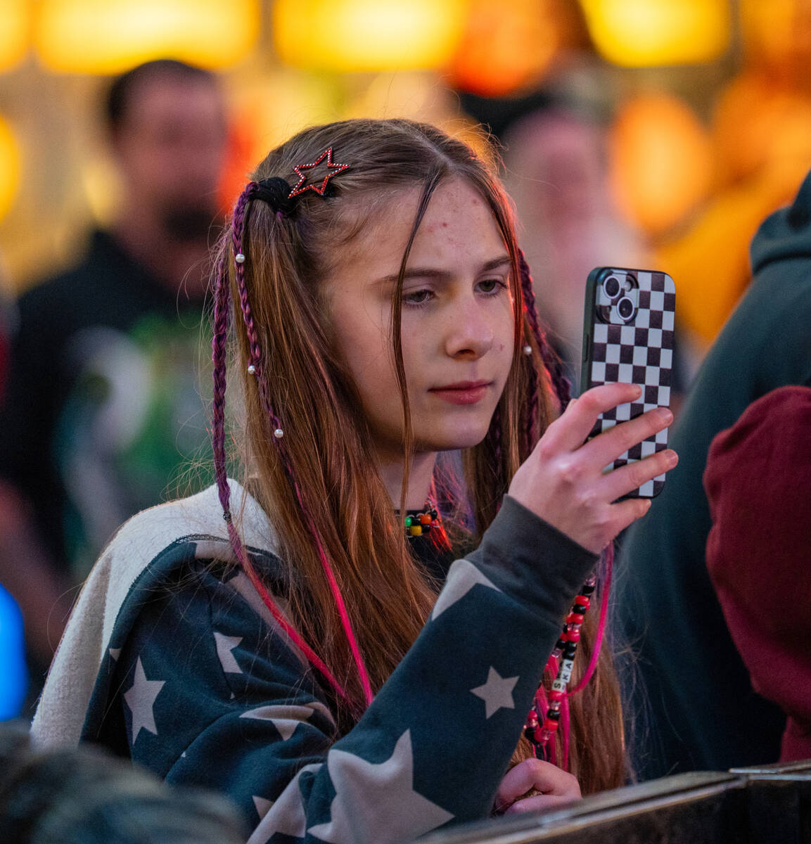 A fan records as The Dollheads preform on the Main Street stage during the Neon City Music Fest ...