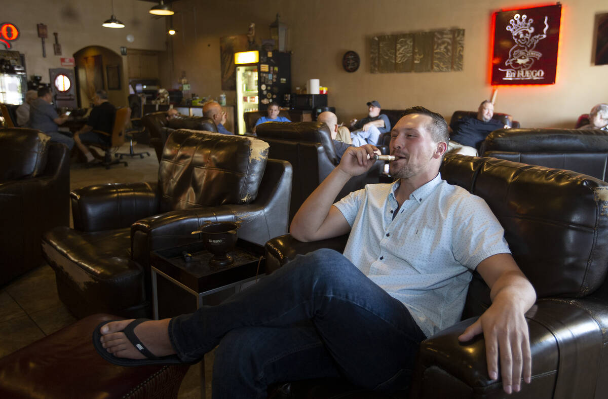 Comedian Rocky Dale Davis smokes a cigar at his regular hangout, En Fuego Cigars & Lounge, ...