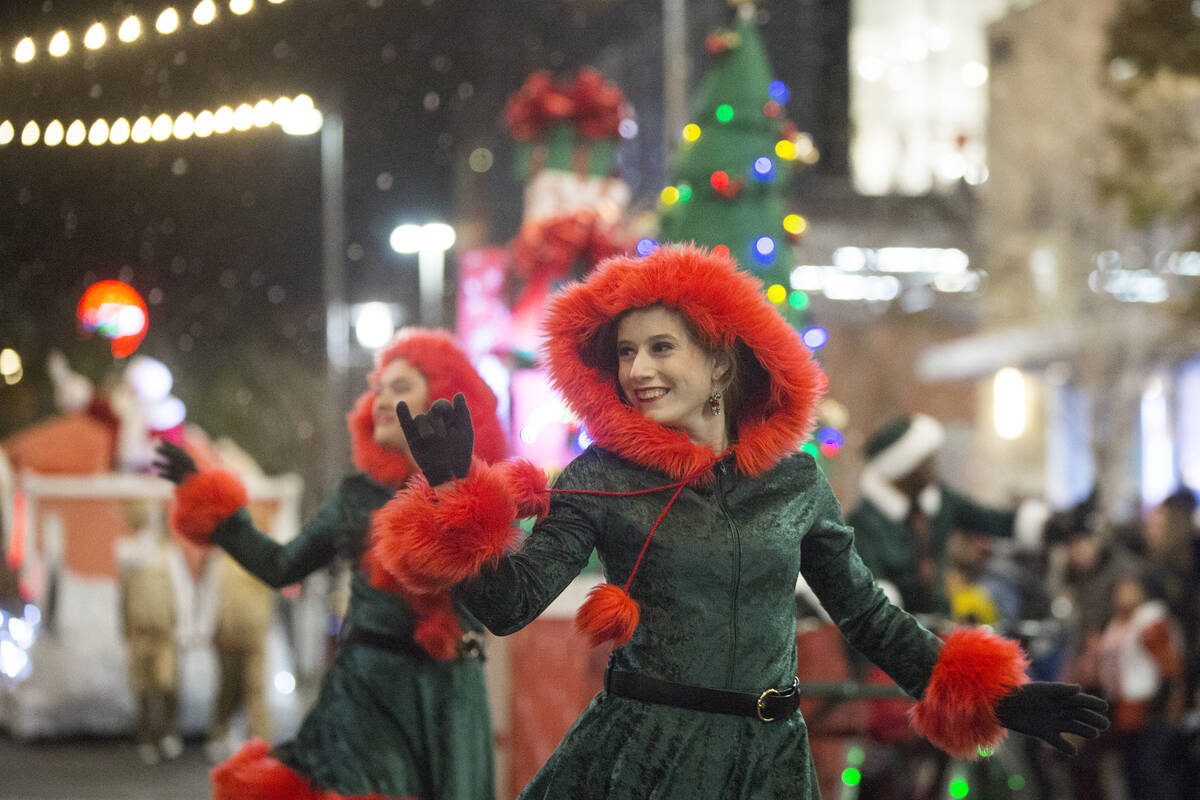 Performers wave to the crowd as the Downtown Summerlin Holiday Parade makes its way through Fes ...
