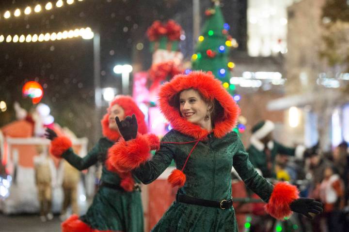 Performers wave to the crowd as the Downtown Summerlin Holiday Parade makes its way through Fes ...