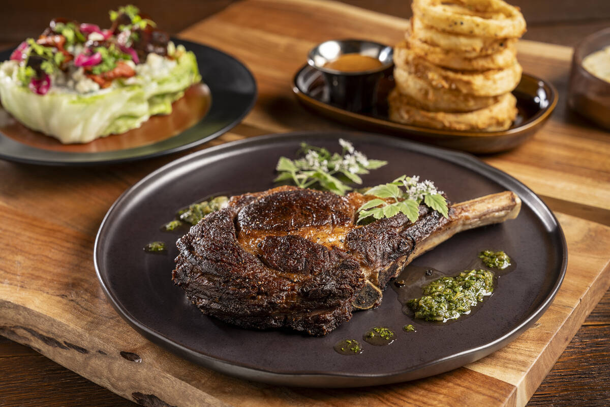 A tomahawk steak, Texas Wedge salad and a side of crispy onions at Four Sixes Ranch Steakhouse, ...