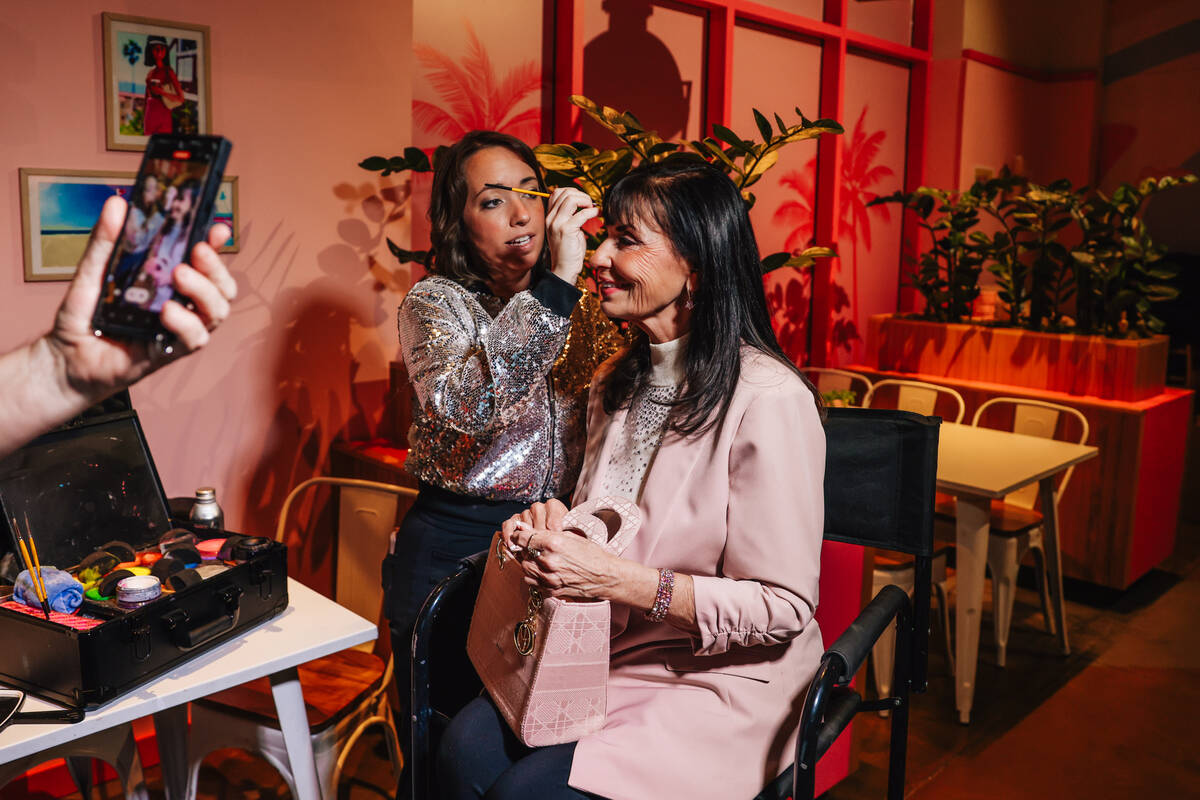 An attendee gets face paint during the grand opening of the Malibu Barbie Cafe at Area15 Wednes ...