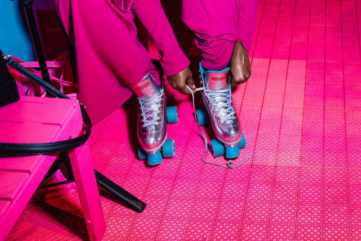 An attendee ties up a roller skate during the grand opening of the Malibu Barbie Cafe at Area15 ...