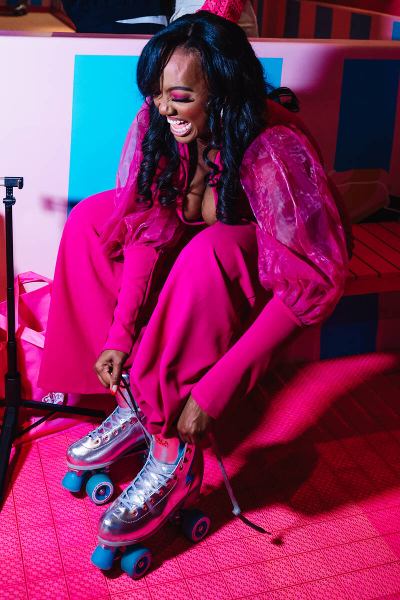 An attendee ties up a roller skate during the grand opening of the Malibu Barbie Cafe at Area15 ...