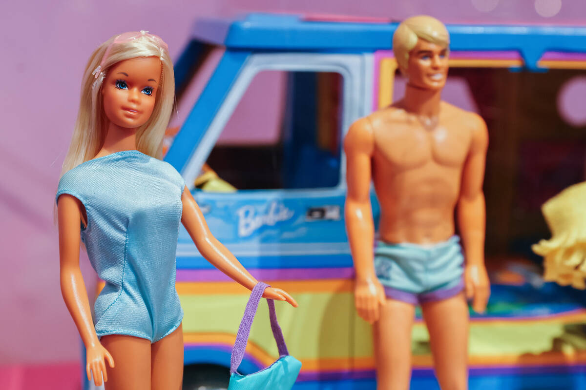 A Malibu Barbie and Ken stand in a display case during a media preview of the Malibu Barbie Caf ...