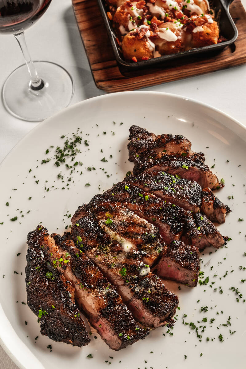 Prime bone-in ribeye with potato croquettes from Delmonico Steakhouse, created by celebrated ch ...