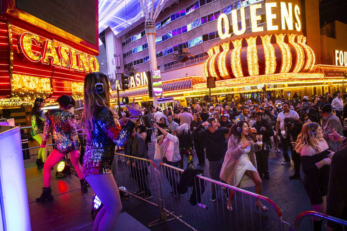 People dance to a silent disco party during the New Year's Eve celebration at the Fremont ...
