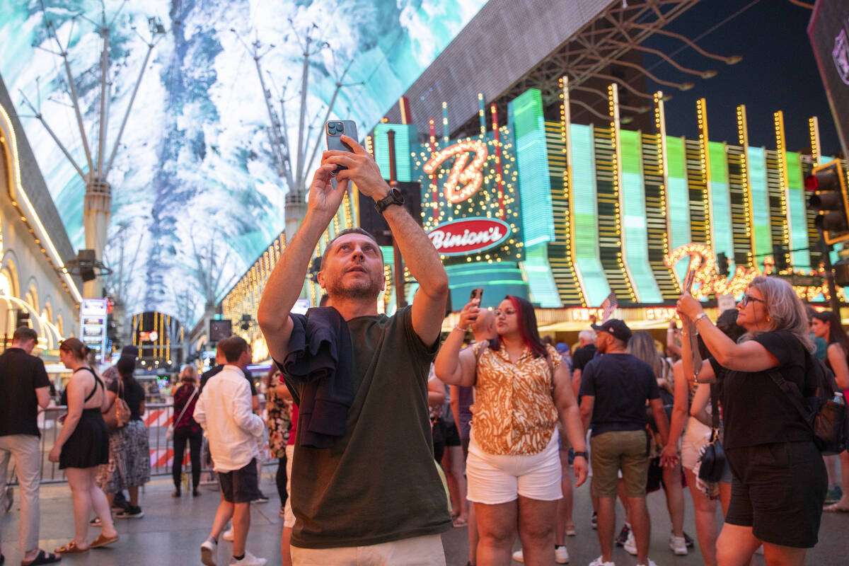 Tourists capture the video canopy at the Fremont Street Experience, Wednesday, Aug. 14, 2024, i ...