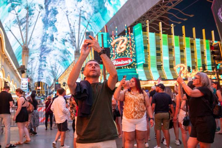 Tourists capture the video canopy at the Fremont Street Experience, Wednesday, Aug. 14, 2024, i ...