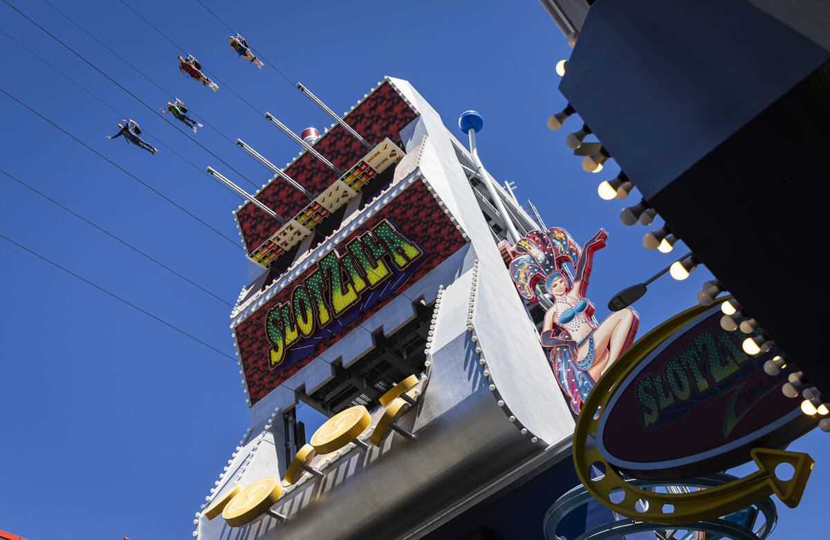 People ride on a zip line at SlotZilla at the Fremont Street Experience on Monday, Aug. 18, 202 ...