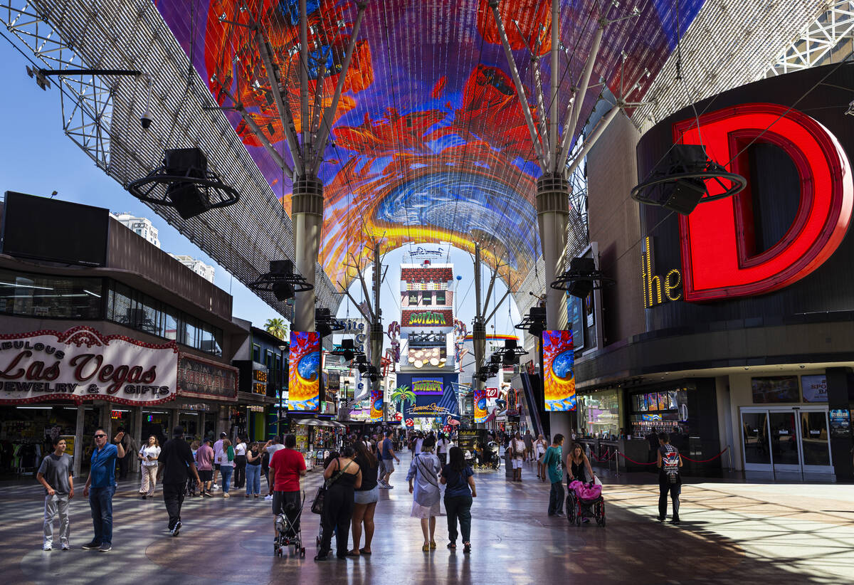 People walk along the Fremont Street Experience on Monday, Aug. 18, 2025, in Las Vegas. (Chase ...