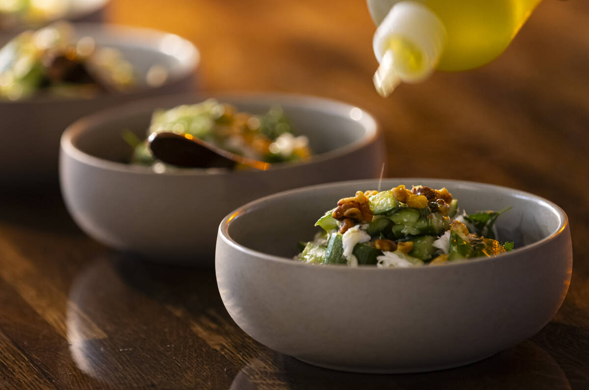 Dungeness crab with cucumber and walnuts is prepared during a staff menu tasting at Ada’ ...