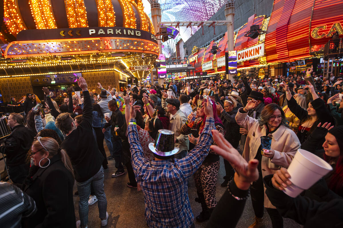 People dance to music during the New Year’s Eve celebration at the Fremont Street Experience ...