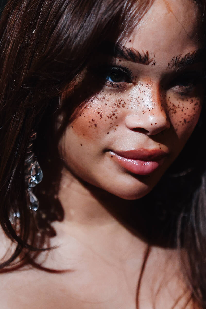 A guest poses on a red carpet during the opening party at Gymkhana in the Aria Friday, Jan. 16, ...