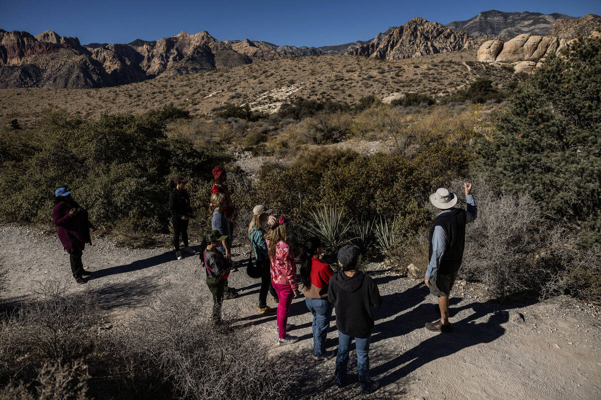 Adventure tour guide Mike Metzger, top/right, points out significant elements of Red Rock Canyo ...