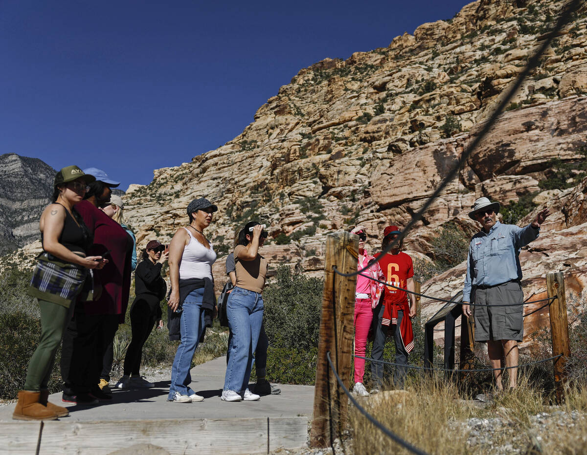 Adventure tour guide Mike Metzger, top/right, points out significant elements of Red Rock Canyo ...