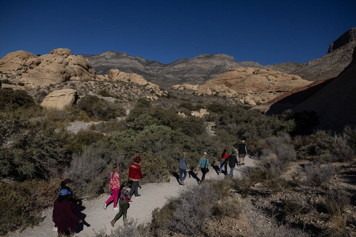 Adventure tour guide Mike Metzger, top/right, points out significant elements of Red Rock Canyo ...