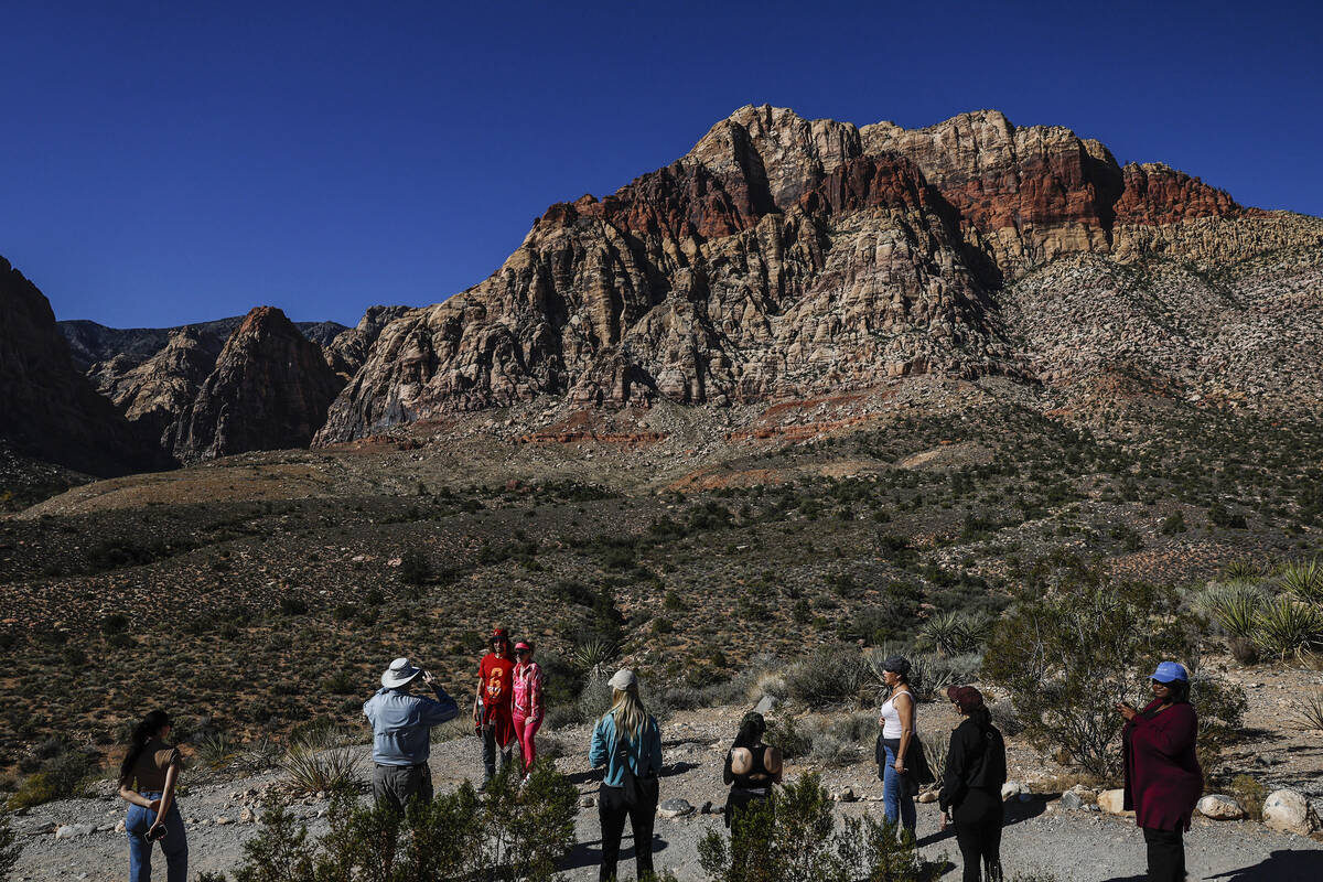 Adventure tour guide Mike Metzger, second from left, takes photos of clients at Red Rock Canyon ...