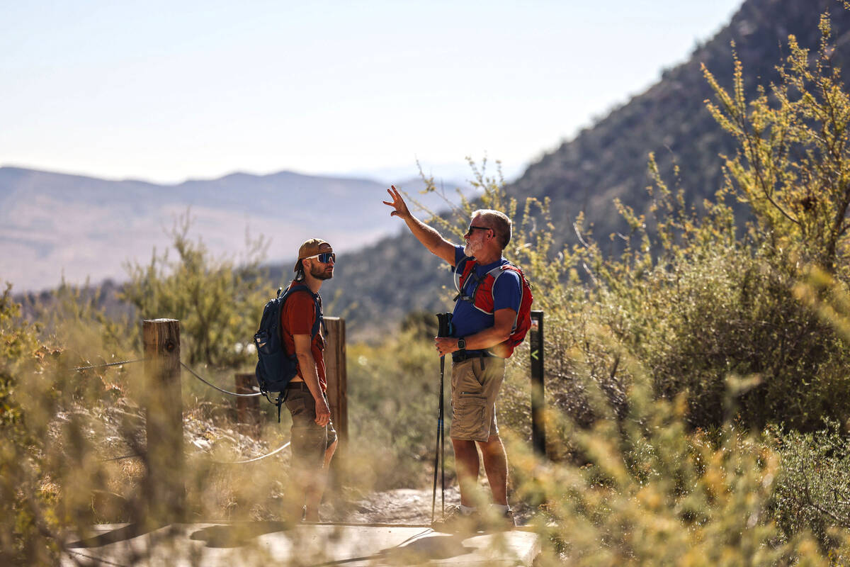 Hikers pass by clients taking a Pink Jeep Tour at Red Rock Canyon National Conservation Area Tu ...