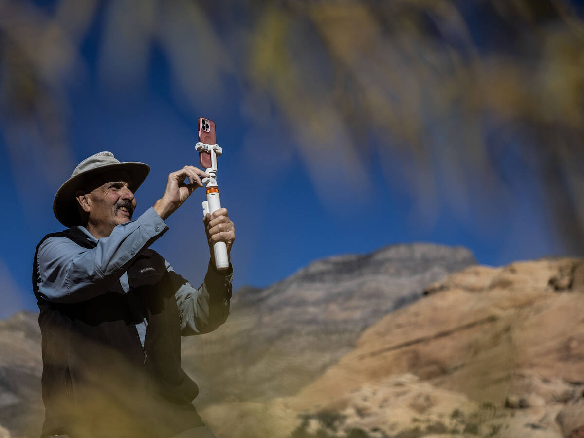 Adventure tour guide Mike Metzger takes photos of clients at Red Rock Canyon National Conservat ...