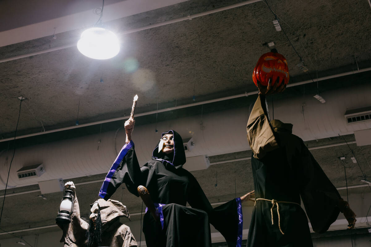 An overhead light illuminates statues from Morris Costumes during the Halloween and Costume Ass ...