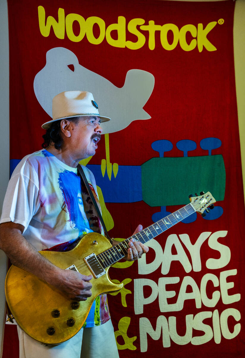 Carlos Santana plays his guitar in front of an Woodstock banner, he hoping to create a new conc ...