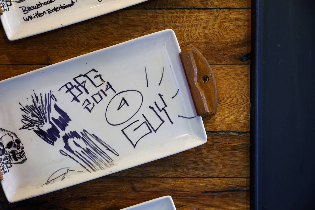 Signed dishes hang on the wall on Friday, Dec. 5, 2025 at Guy Fieri's Vegas Kitchen & ...
