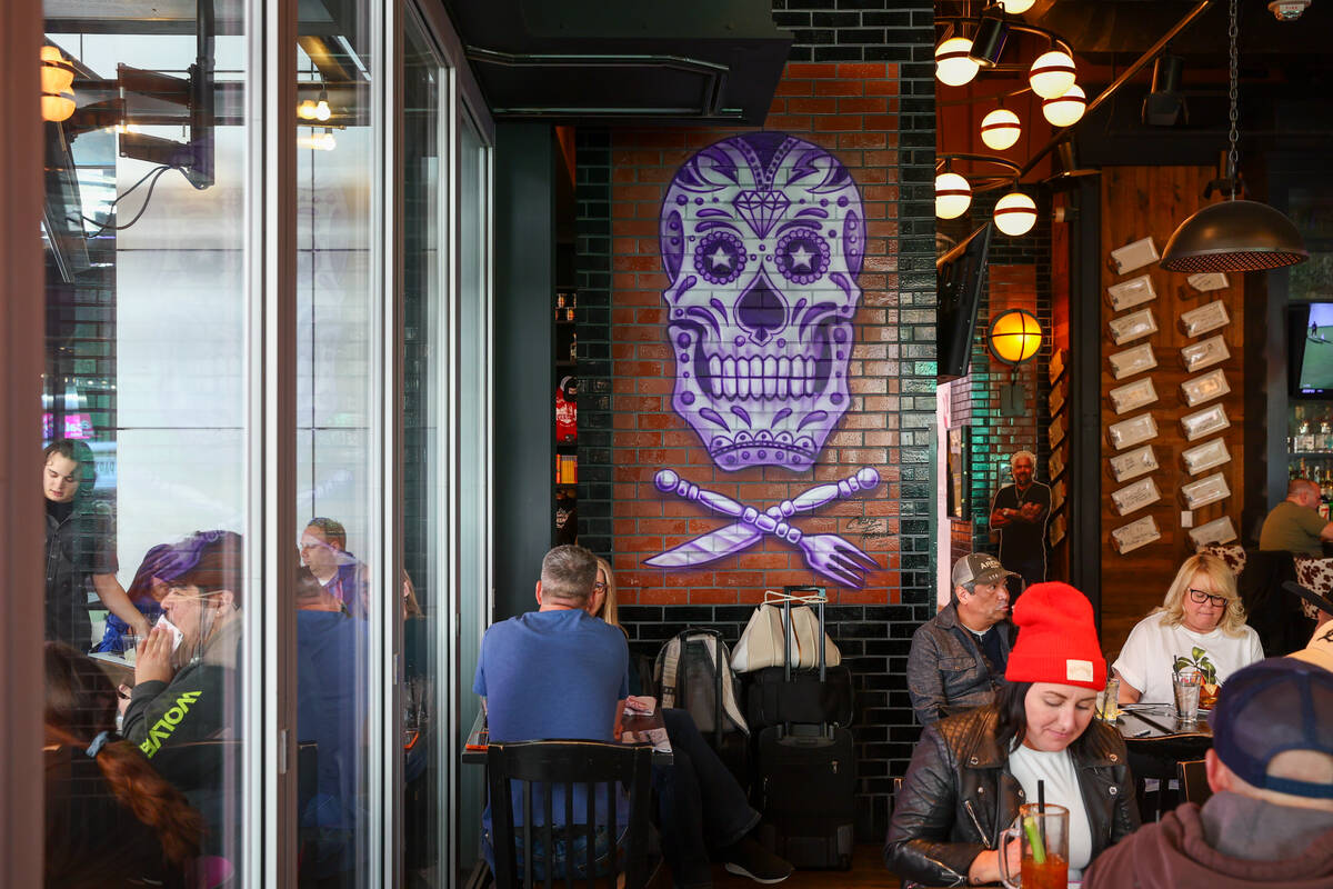 Diners sit underneath a purple skull mural on Friday, Dec. 5, 2025 at Guy Fieri's Vegas Ki ...