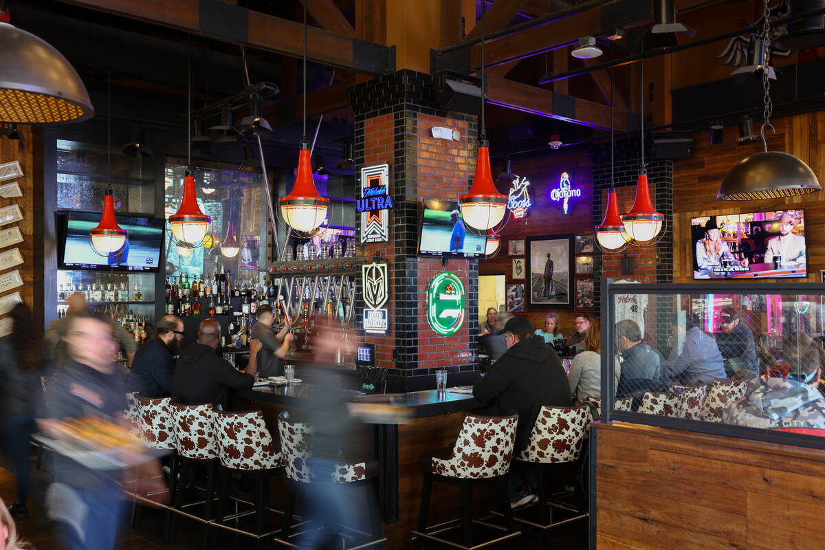 Guests sit at the bar as waiters rush by on Friday, Dec. 5, 2025 at Guy Fieri's Vegas Kitc ...