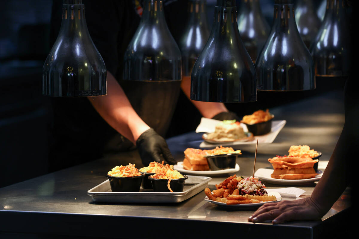 Dishes wait under heat lamps to be delivered to tables on Friday, Dec. 5, 2025 at Guy Fieri ...