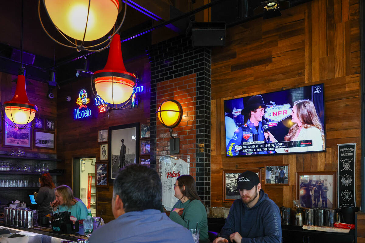 National Finals Rodeo highlights play on a television by the bar on Friday, Dec. 5, 2025 at Guy ...