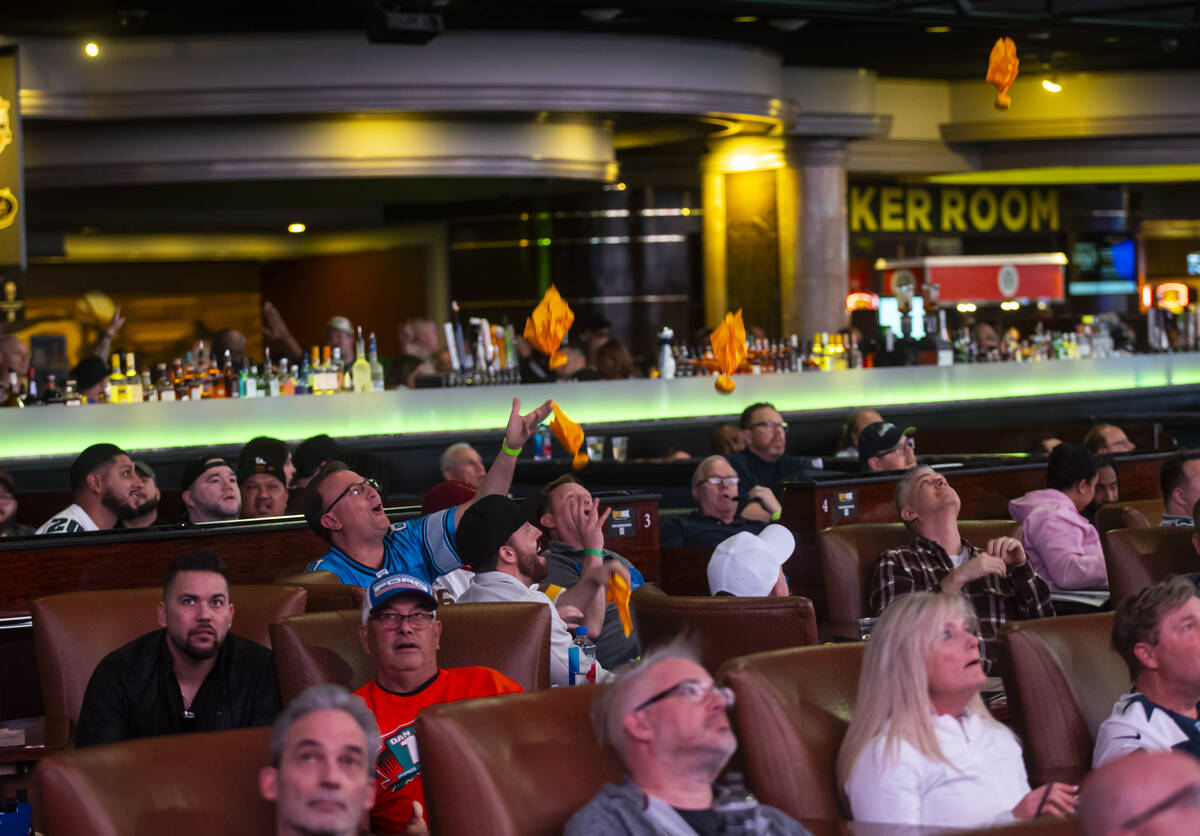 Football fans throw penalty flags into the air while watching Super Bowl 59 between the Philade ...